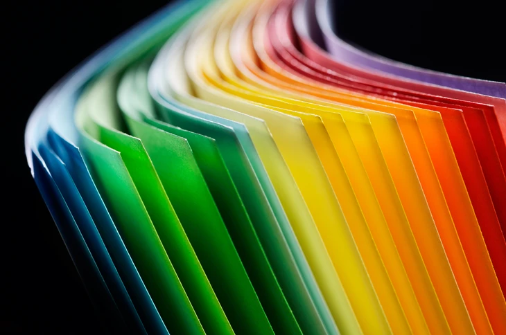 Composition artistique d'échantillons de papier coloré disposés en éventail sur fond noir