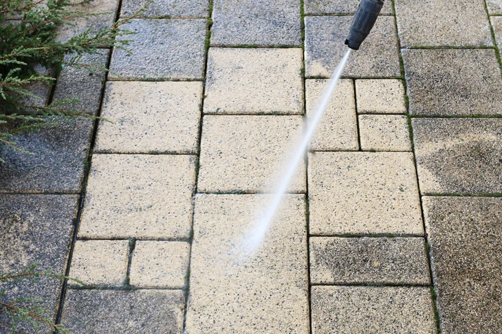 Nettoyage des pavés sales dans le jardin avec un lave-pression