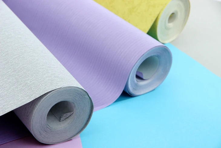 Intérieur d'atelier ou magasin de décoration avec rouleaux de papier peint colorés disposés sur surface claire