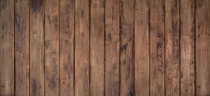 Surface de planches en bois naturel vieilli disposées verticalement, présentant des nuances brunes chaleureuses et des veines apparentes