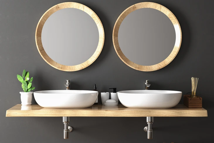 Salle de bain moderne avec double vasque blanche ovale posée sur plan de travail en bois massif