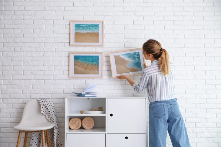 Le décorateur accroché au mur de briques blanches de la chambre