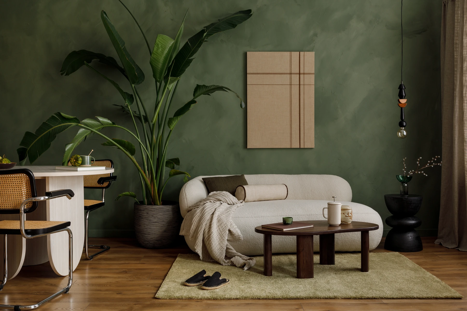 Photographie en gros plan montrant une main gantée tenant un pinceau professionnel appliquant une peinture murale de couleur neutre sur un mur intérieur lisse préalablement préparé. La texture du mur et la technique d'application doivent être clairement visibles, illustrant le professionnalisme et la précision du travail de finition en peinture intérieure.